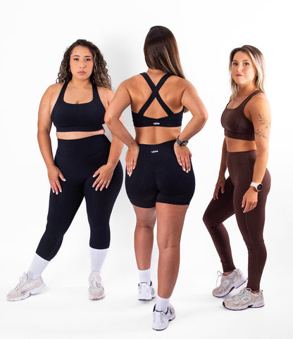 Three women modeling athletic wear on a white background