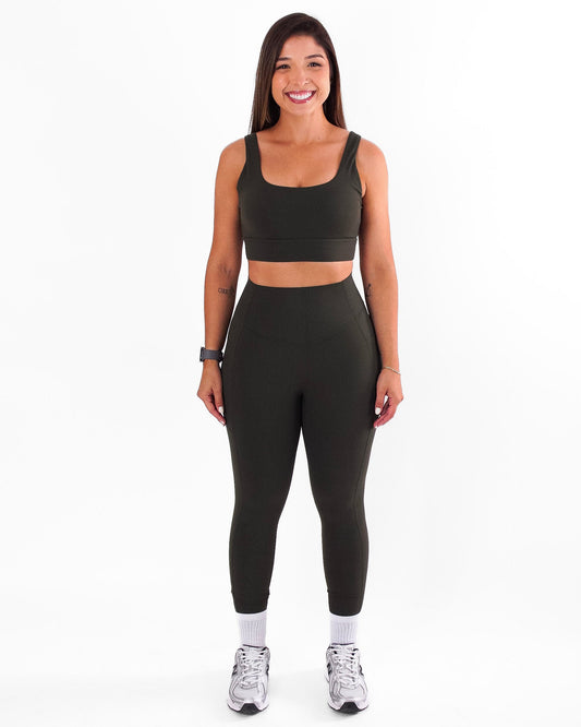 Woman wearing a green athletic outfit on a white background